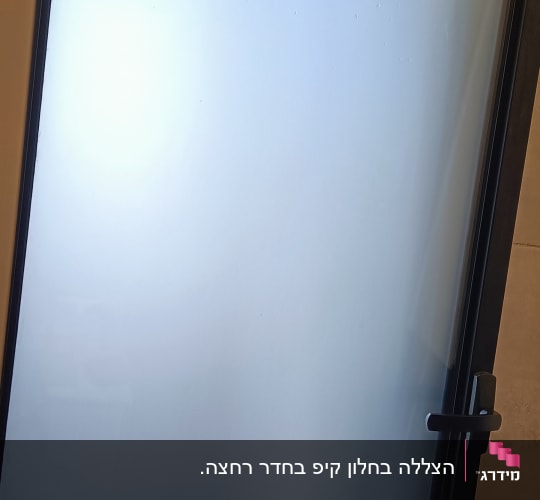 חלון זכוכית חלבית עם מסגרת מתכת שחורה
